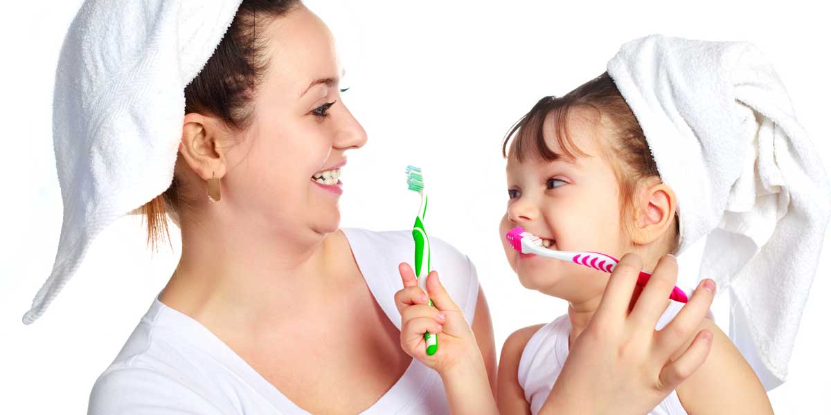 Happy Mother and Daughter are Brushing Their Teeth